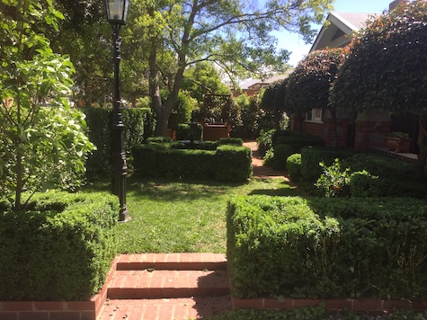 An elegant garden with mown lawns, trimmed hedges and tidy edges